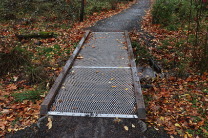Compacted gravel trail with smooth transition to metal grate with edge protection